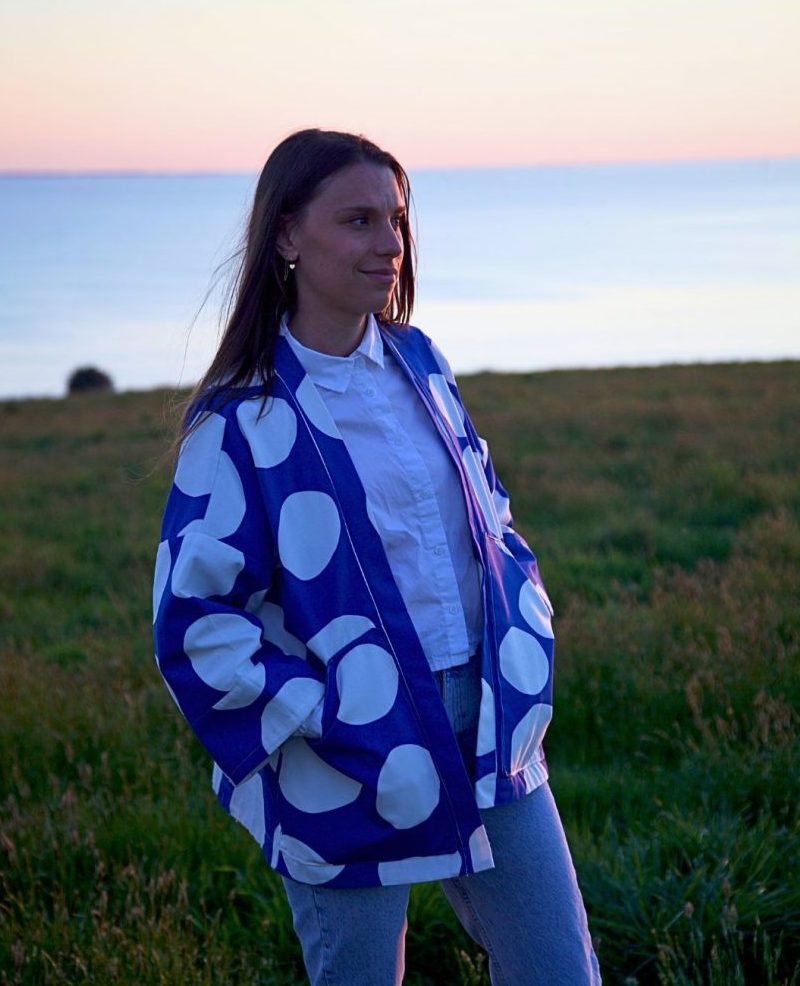 Accueil Veste kimono Carla en coton bleu rigide à ronds blancs, manches amples 3/4, coupe droite, poches plates visibles.