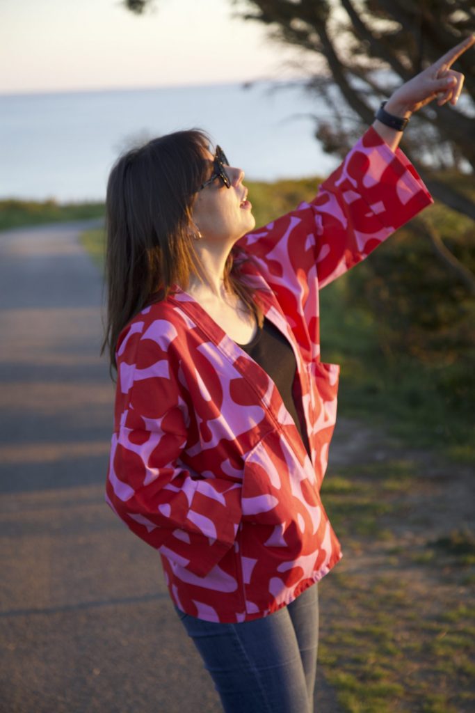 Veste kimono rose et rouge Charline Veste kimono ample en coton rose et rouge, manches larges 3/4, poches plates sur les côtés, vue de profil.