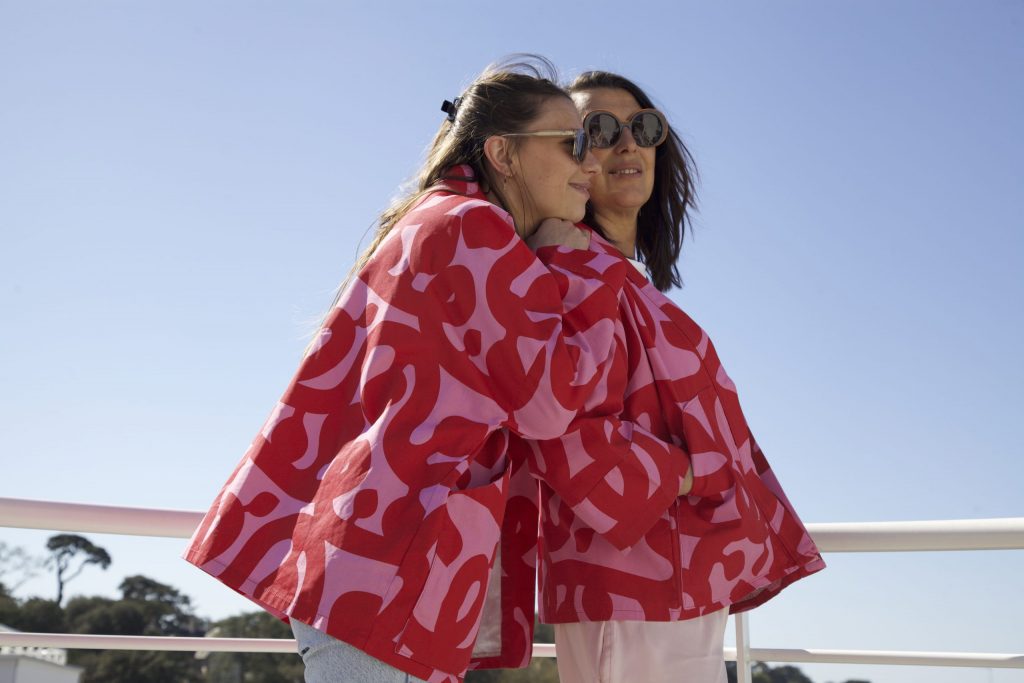 Veste kimono ample en coton rose et rouge, manches larges 3/4, poches plates sur les côtés, vue de profil. Duo