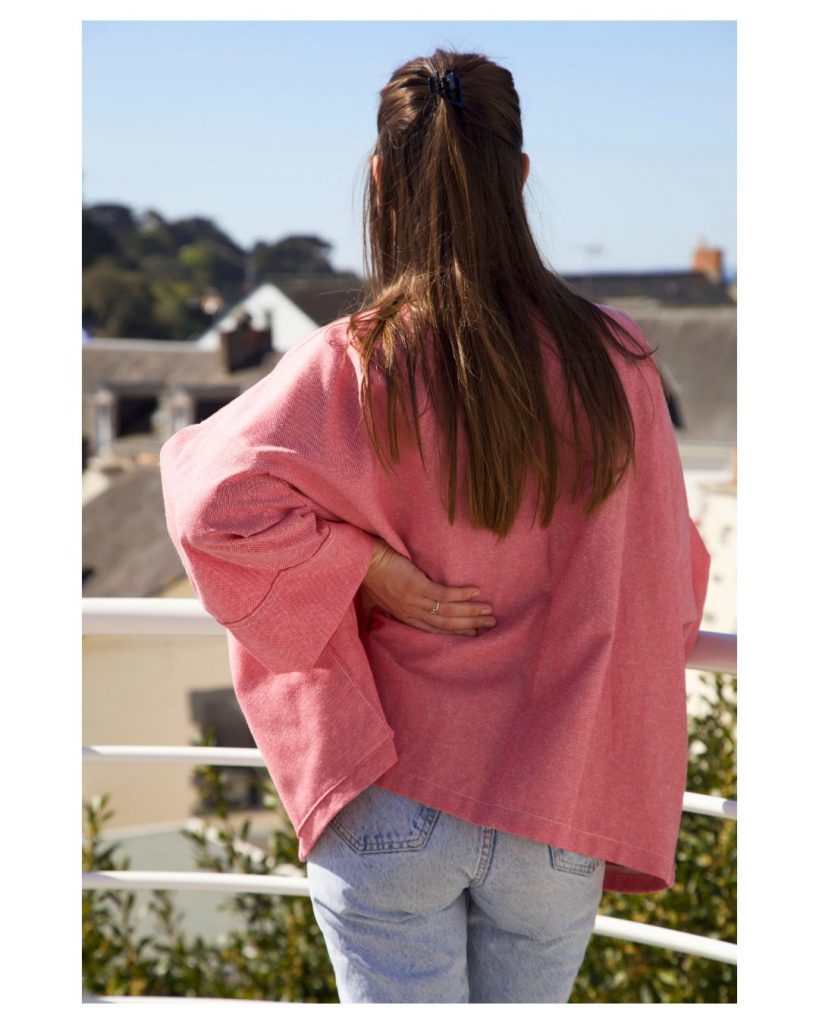 Veste kimono Rose poches plates de dos Veste Kimono court ample en coton naturel rose foncé, manches droites, poches plates discrètes, coupe fluide confortable. De dos
