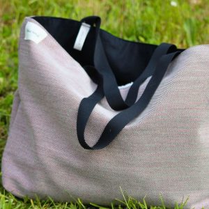 Sac cabas souple en tissu texturé rosé avec anses noires et doublure coton noir, réversible.