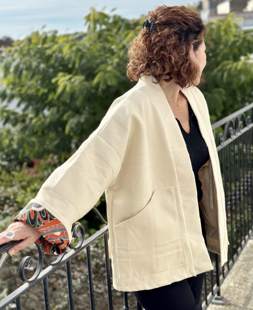 Blandine profil Veste kimono BLANDINE, vue de côté, tissu beige épais, revers contrastés automne ou doré.