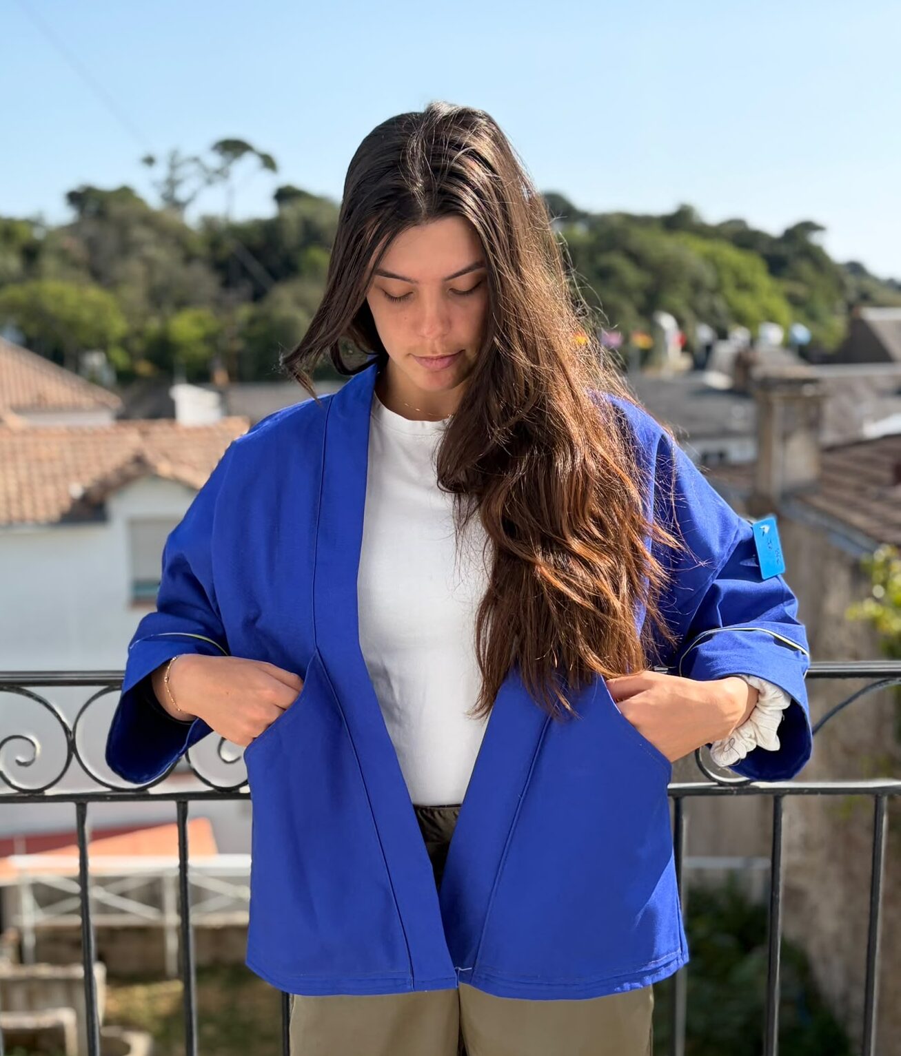 job de face Veste kimono mixte en toile de coton bleu cobalt avec liserés jaunes au col et aux manches, coupe oversize inspirée du style japonais.