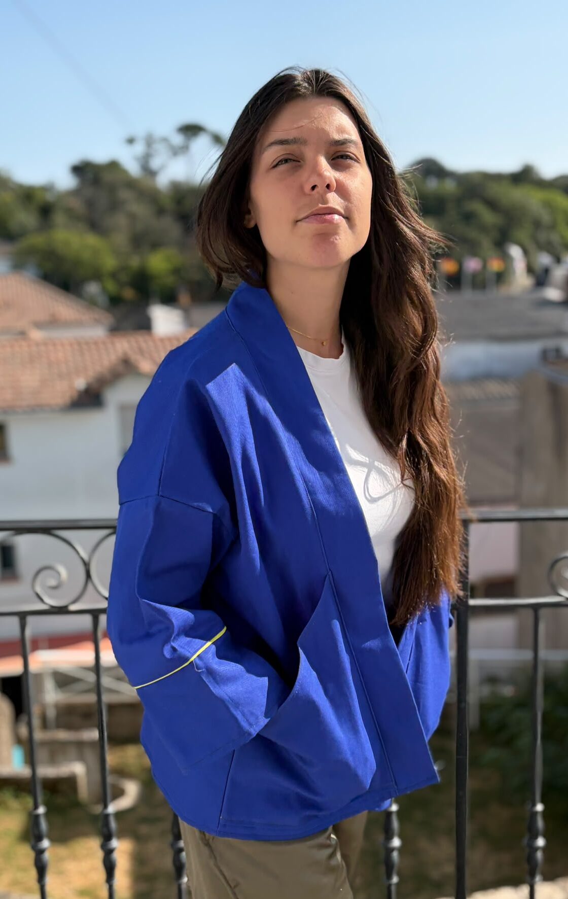 Veste kimono Job bleu cobalt de face Veste kimono mixte en toile de coton bleu cobalt avec liserés jaunes au col et aux manches, coupe oversize inspirée du style japonais.