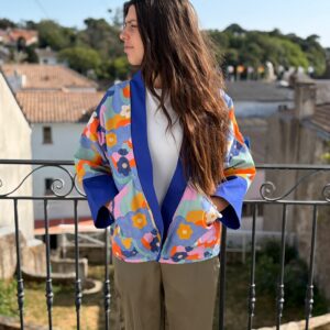 Découvrez notre veste kimono artisanale au motif rétro chic et fleurs pop. Une création originale avec revers bleu électrique pour un style unique.